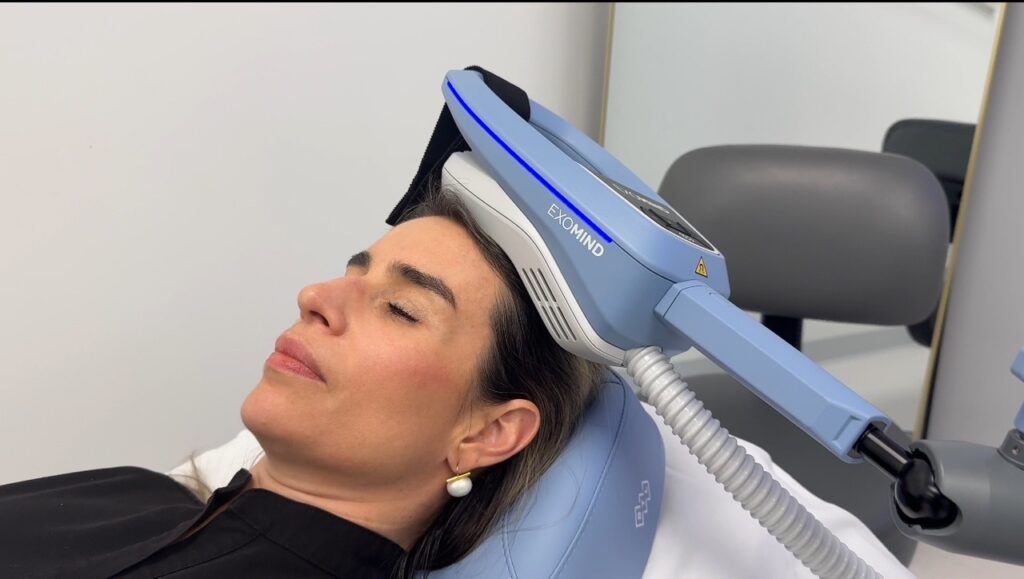 Image of a brunette woman relaxing at Lumina Vein & Aesthetics while receiving Exomind near Orlando.